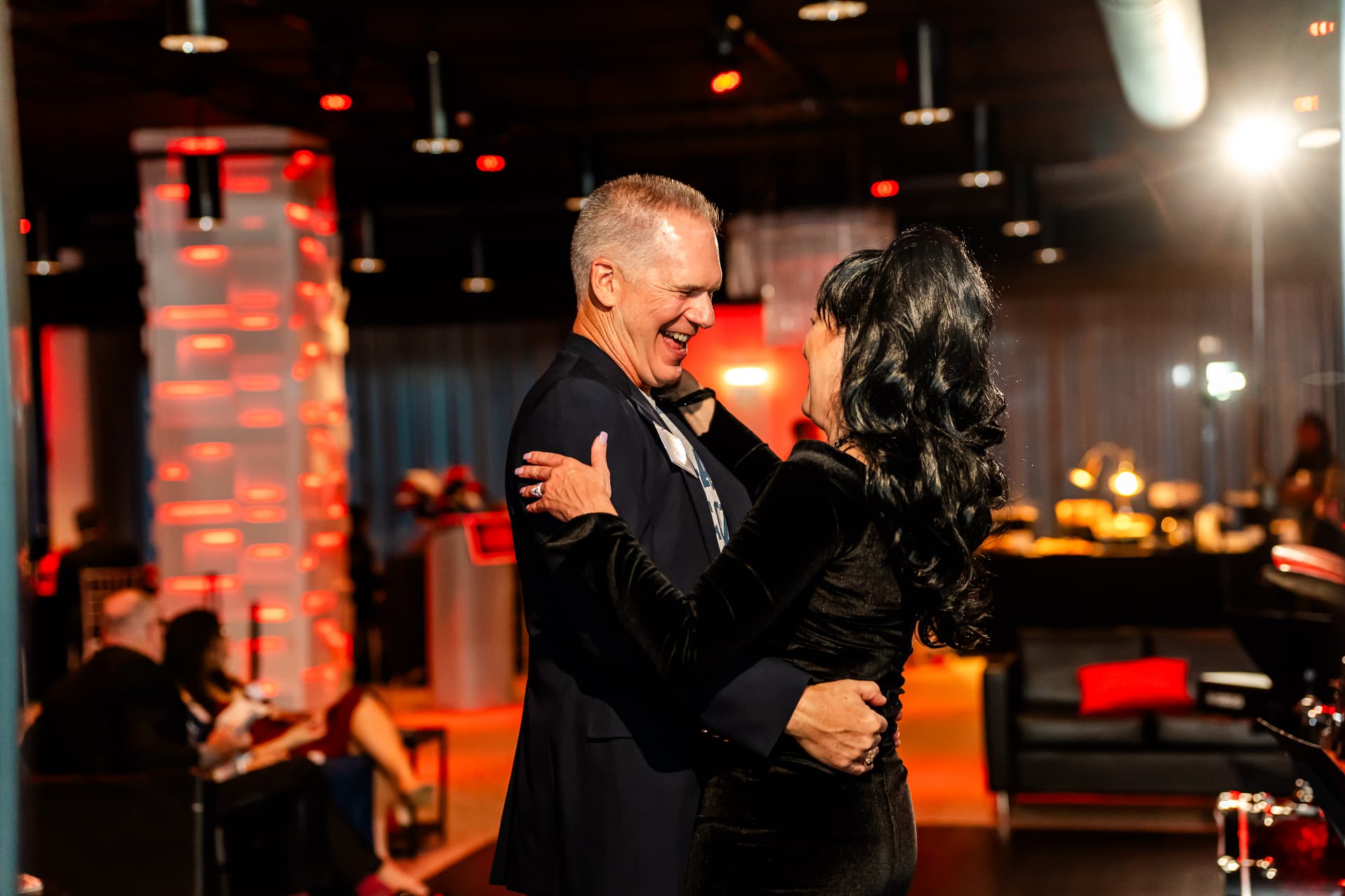 Guests dancing under red event lighting during a celebration at The MEZZ